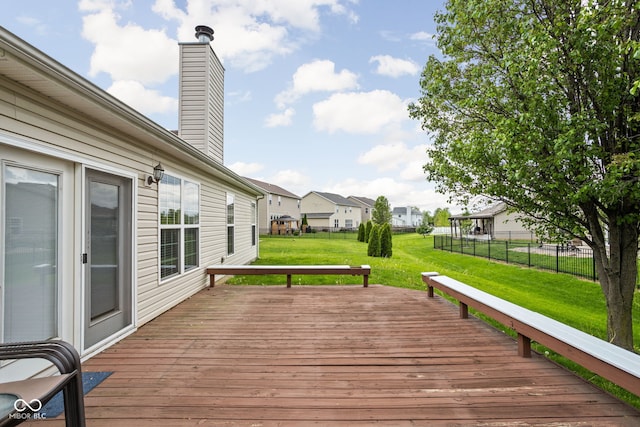 wooden terrace with a lawn, fence, and a residential view
