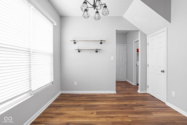 interior space featuring an inviting chandelier, baseboards, and wood finished floors