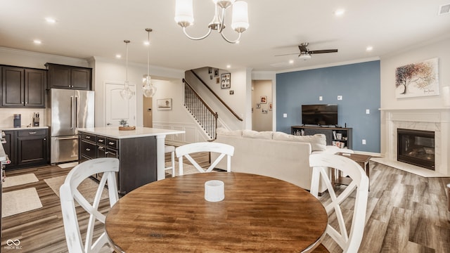 14878 Anees Ln, Fishers, IN 46040 - dining room with a ceiling fan, light wood-style floors, stairs, crown molding, and recessed lighting