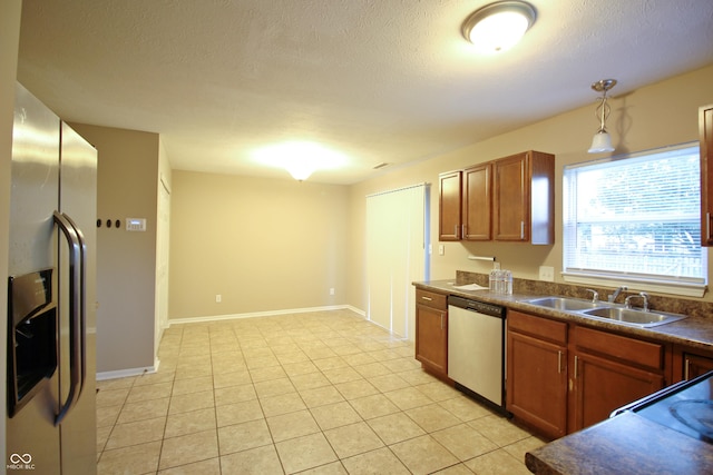 6634 Frankenberger Dr, Indianapolis, IN 46237 - kitchen featuring stainless steel appliances, dark countertops, brown cabinetry, a textured ceiling, and decorative light fixtures