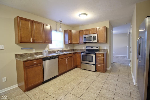 6634 Frankenberger Dr, Indianapolis, IN 46237 - kitchen featuring appliances with stainless steel finishes, brown cabinetry, dark countertops, and light tile patterned floors