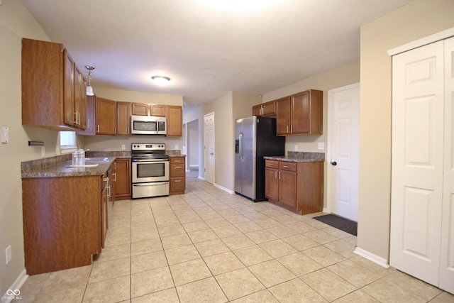 6634 Frankenberger Dr, Indianapolis, IN 46237 - kitchen featuring stainless steel appliances, brown cabinets, dark countertops, and light tile patterned flooring