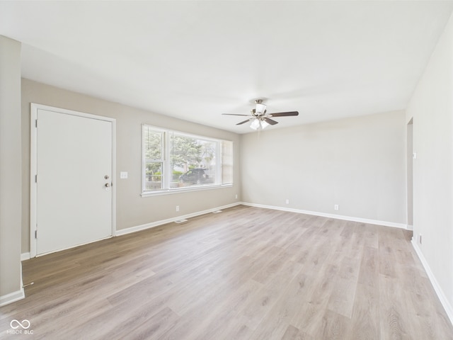 interior space with baseboards, a ceiling fan, light wood-style flooring, and visible vents