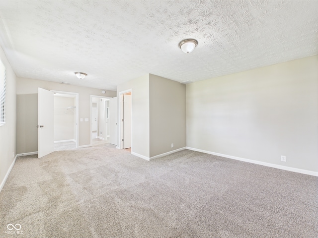 carpeted spare room with baseboards and a textured ceiling