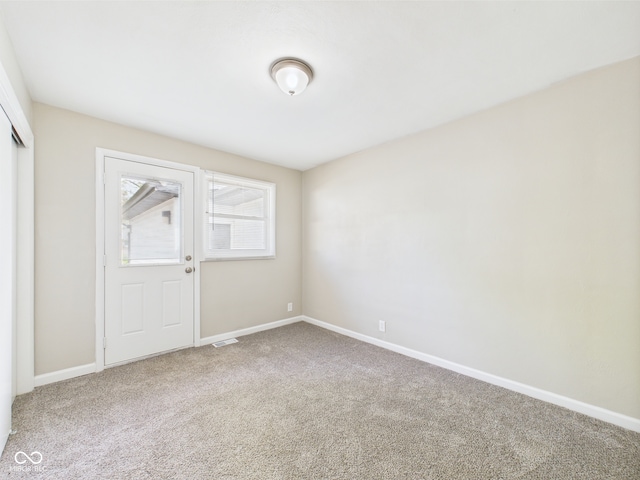 carpeted spare room with baseboards and visible vents