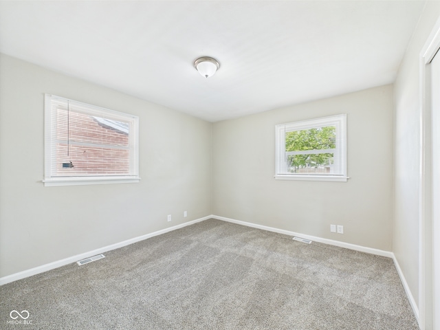 carpeted empty room with visible vents and baseboards