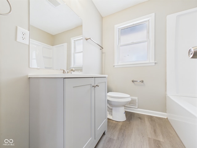 full bath featuring toilet, baseboards, visible vents, and wood finished floors