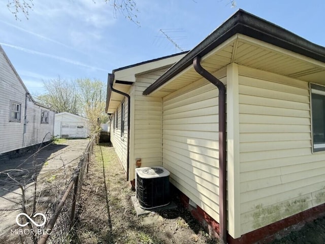 view of home's exterior featuring central air condition unit and fence