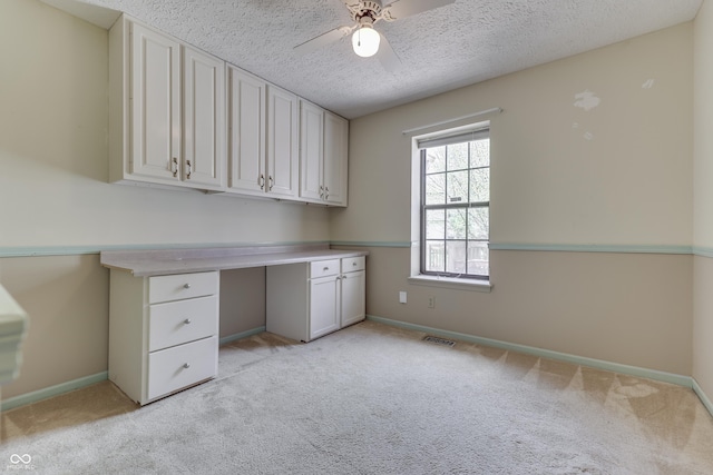 unfurnished office with baseboards, light carpet, a ceiling fan, and visible vents