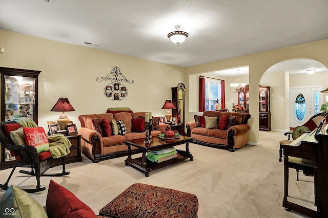 living area with arched walkways, visible vents, a chandelier, and light colored carpet