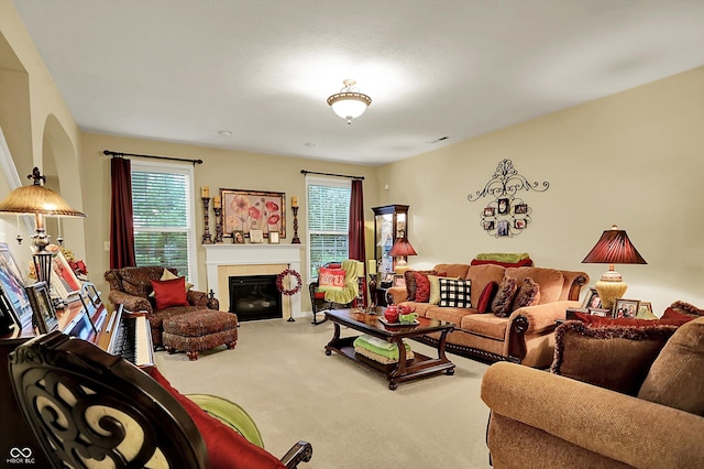 carpeted living room featuring a glass covered fireplace and visible vents