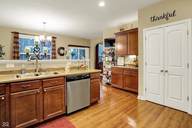 kitchen with arched walkways, dishwasher, a sink, an inviting chandelier, and light wood-style flooring