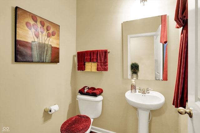 bathroom featuring a sink, baseboards, and toilet