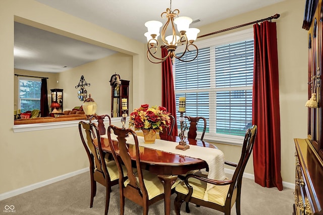 dining room featuring carpet floors, baseboards, and an inviting chandelier