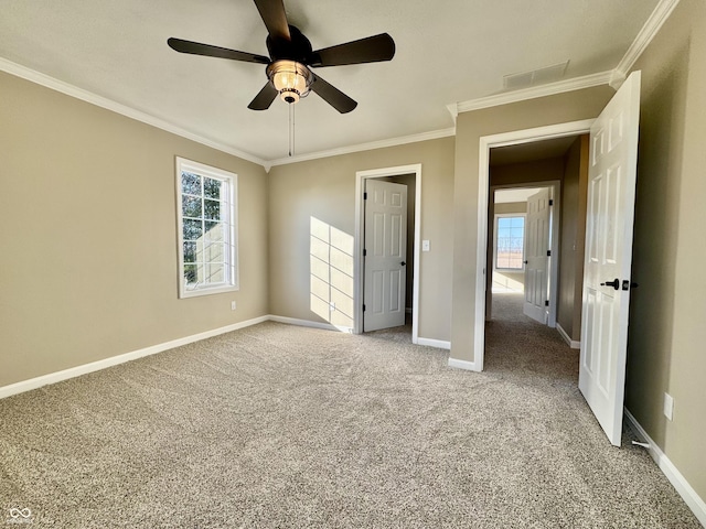 unfurnished bedroom featuring crown molding, visible vents, baseboards, ceiling fan, and light colored carpet