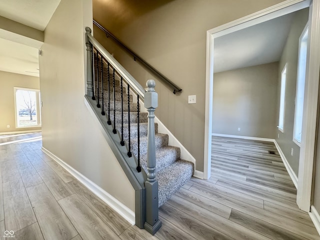 stairway featuring wood finished floors and baseboards