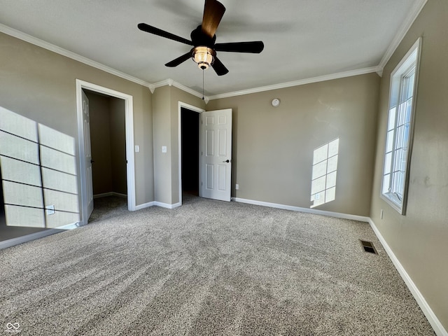 unfurnished bedroom with carpet, visible vents, crown molding, ceiling fan, and baseboards
