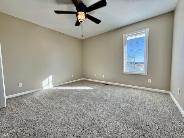carpeted spare room featuring a ceiling fan, baseboards, and visible vents