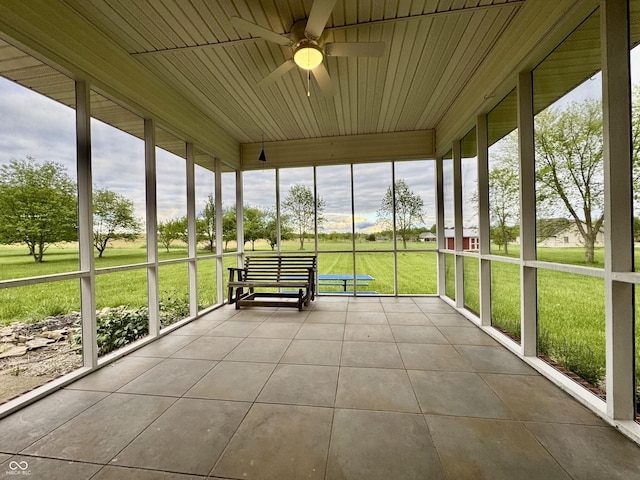 unfurnished sunroom featuring ceiling fan