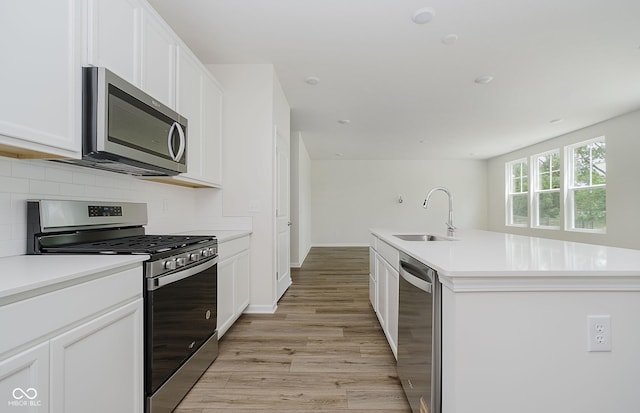 6871 Seabiscuit Rd, Whitestown, IN 46075 - kitchen with appliances with stainless steel finishes, decorative backsplash, light wood-style floors, and white cabinetry