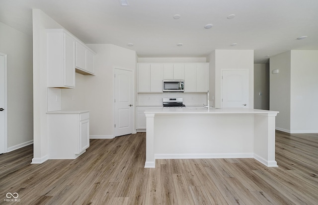 6871 Seabiscuit Rd, Whitestown, IN 46075 - kitchen with stainless steel microwave, electric stove, light wood-style floors, and white cabinets