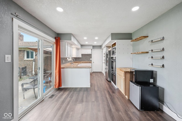1416 Wellington Ave, Indianapolis, IN 46219 - kitchen with a sink, stainless steel microwave, dark wood-type flooring, refrigerator, and visible vents
