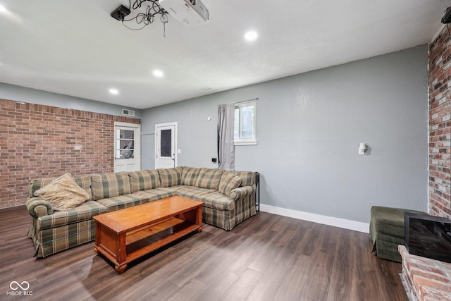 1416 Wellington Ave, Indianapolis, IN 46219 - living room with baseboards, dark wood-style floors, and brick wall