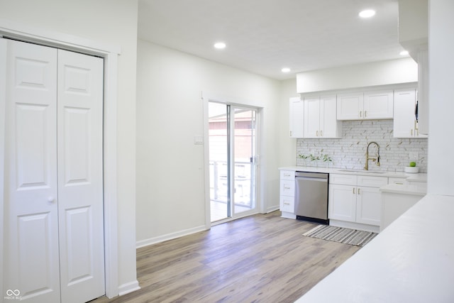 474 N Randolph St, Indianapolis, IN 46201 - kitchen featuring decorative backsplash, stainless steel dishwasher, light wood-type flooring, a sink, and white cabinetry