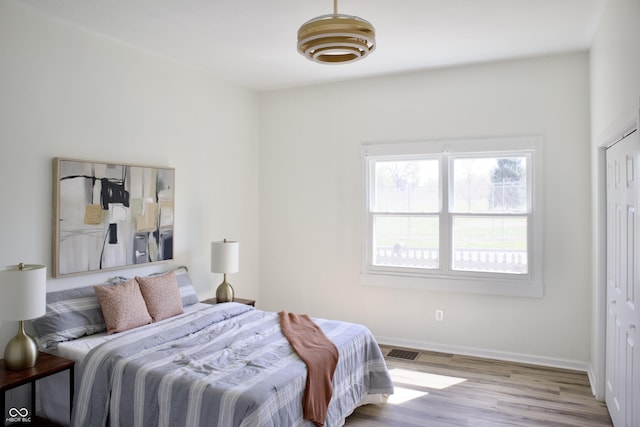474 N Randolph St, Indianapolis, IN 46201 - bedroom with visible vents, baseboards, and wood finished floors