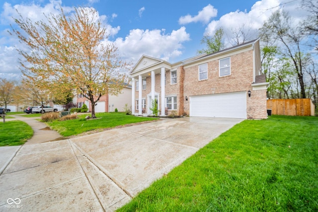 neoclassical home featuring a garage, a front lawn, fence, brick siding, and driveway