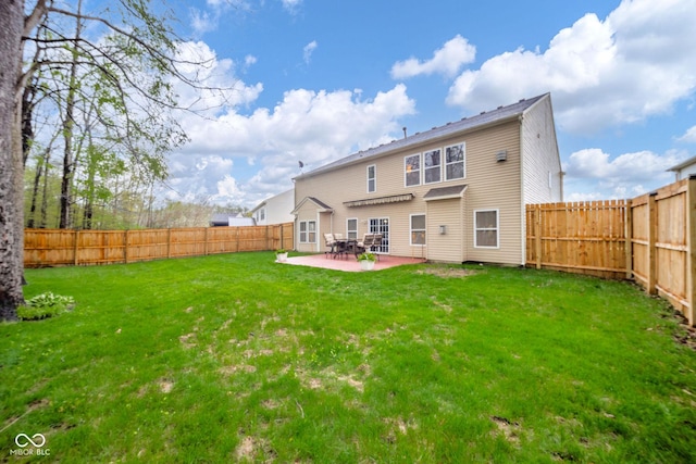 rear view of property with a fenced backyard, a patio, and a yard