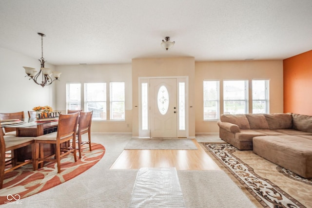entrance foyer featuring an inviting chandelier, a textured ceiling, and plenty of natural light