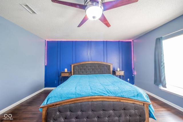 bedroom with baseboards, multiple windows, dark wood-style floors, and visible vents