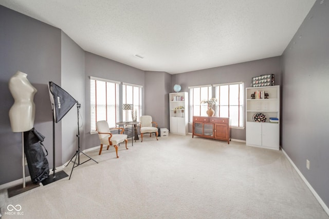 sitting room featuring carpet flooring, baseboards, and plenty of natural light