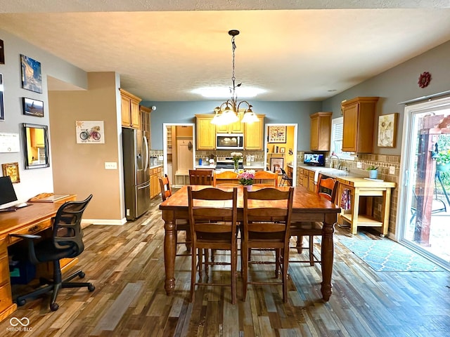 dining space with dark wood finished floors, an office area, and a chandelier