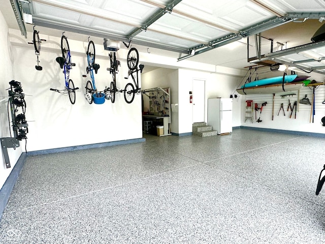 garage with freestanding refrigerator and baseboards