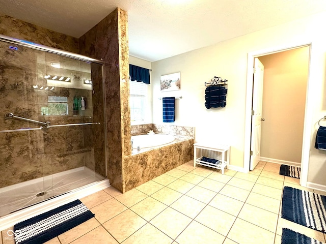 bathroom featuring a stall shower, tile patterned flooring, a garden tub, and a textured ceiling
