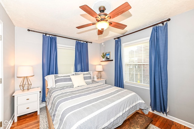 bedroom featuring baseboards, ceiling fan, and wood finished floors