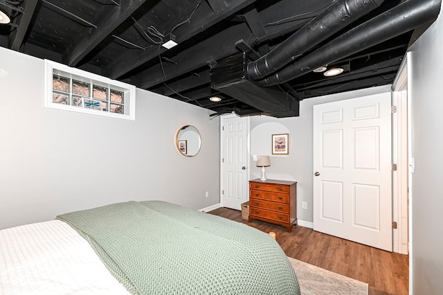 bedroom with baseboards and wood finished floors