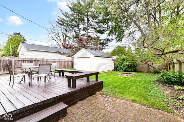 wooden terrace featuring a yard, a fire pit, outdoor dining area, and a fenced backyard
