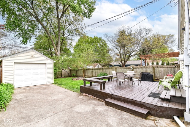 wooden deck with an outdoor structure, a fenced backyard, concrete driveway, outdoor dining space, and a detached garage
