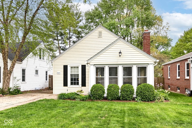 bungalow with a front lawn and a chimney