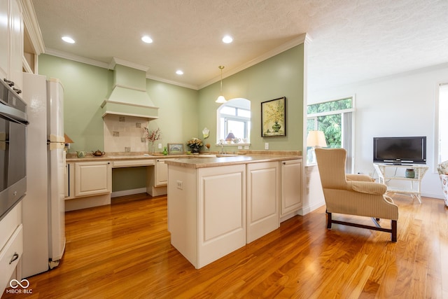 476 Glenview Dr, Greencastle, IN 46135 - kitchen with premium range hood, light countertops, light wood-style floors, pendant lighting, and ornamental molding