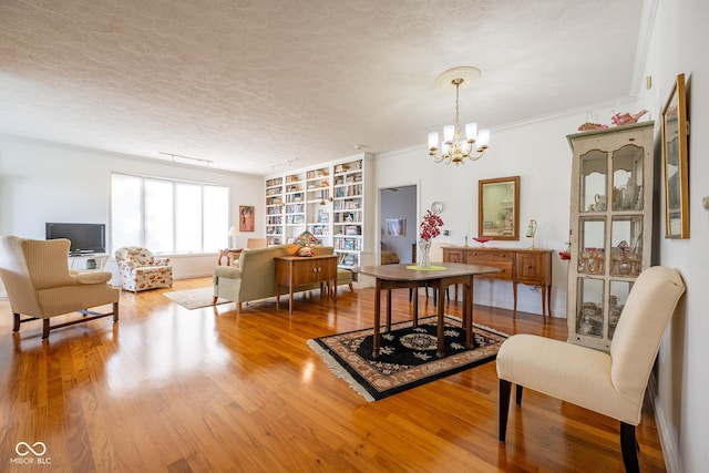 476 Glenview Dr, Greencastle, IN 46135 - dining room featuring a chandelier, wood finished floors, built in features, a textured ceiling, and ornamental molding