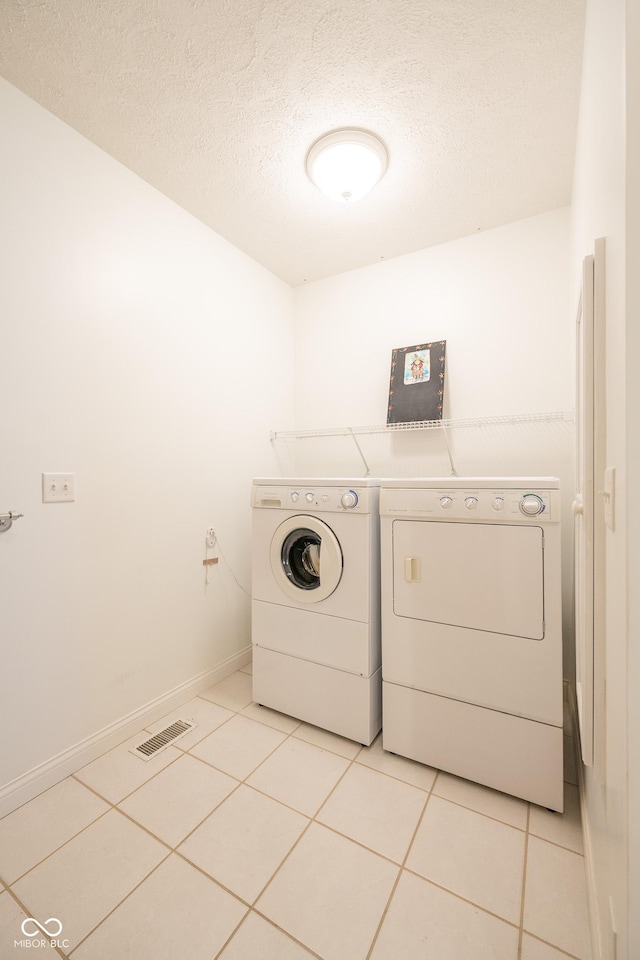 476 Glenview Dr, Greencastle, IN 46135 - laundry room featuring washing machine and dryer, light tile patterned floors, and a textured ceiling