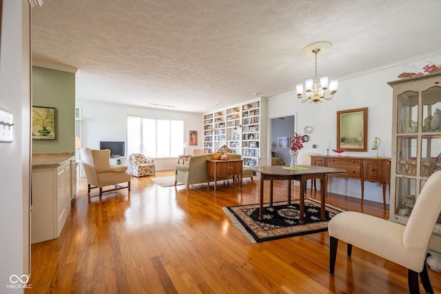 476 Glenview Dr, Greencastle, IN 46135 - dining space featuring wood finished floors, a chandelier, a textured ceiling, built in shelves, and crown molding
