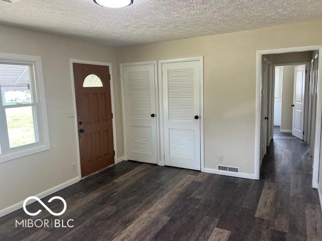 1204 Ladoga Rd, Crawfordsville, IN 47933 - entrance foyer with a textured ceiling, visible vents, dark wood-style floors, and baseboards