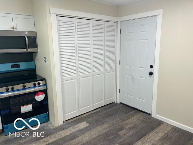 1204 Ladoga Rd, Crawfordsville, IN 47933 - kitchen with white cabinetry, baseboards, appliances with stainless steel finishes, and dark wood-type flooring