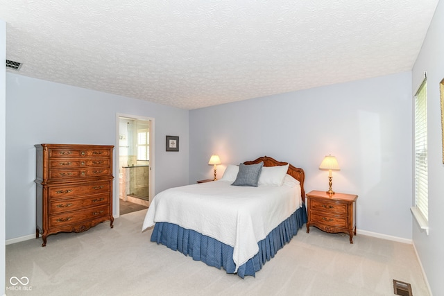 bedroom featuring visible vents, a textured ceiling, and light carpet