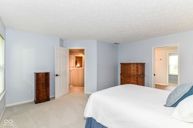 bedroom featuring a textured ceiling, baseboards, and light colored carpet